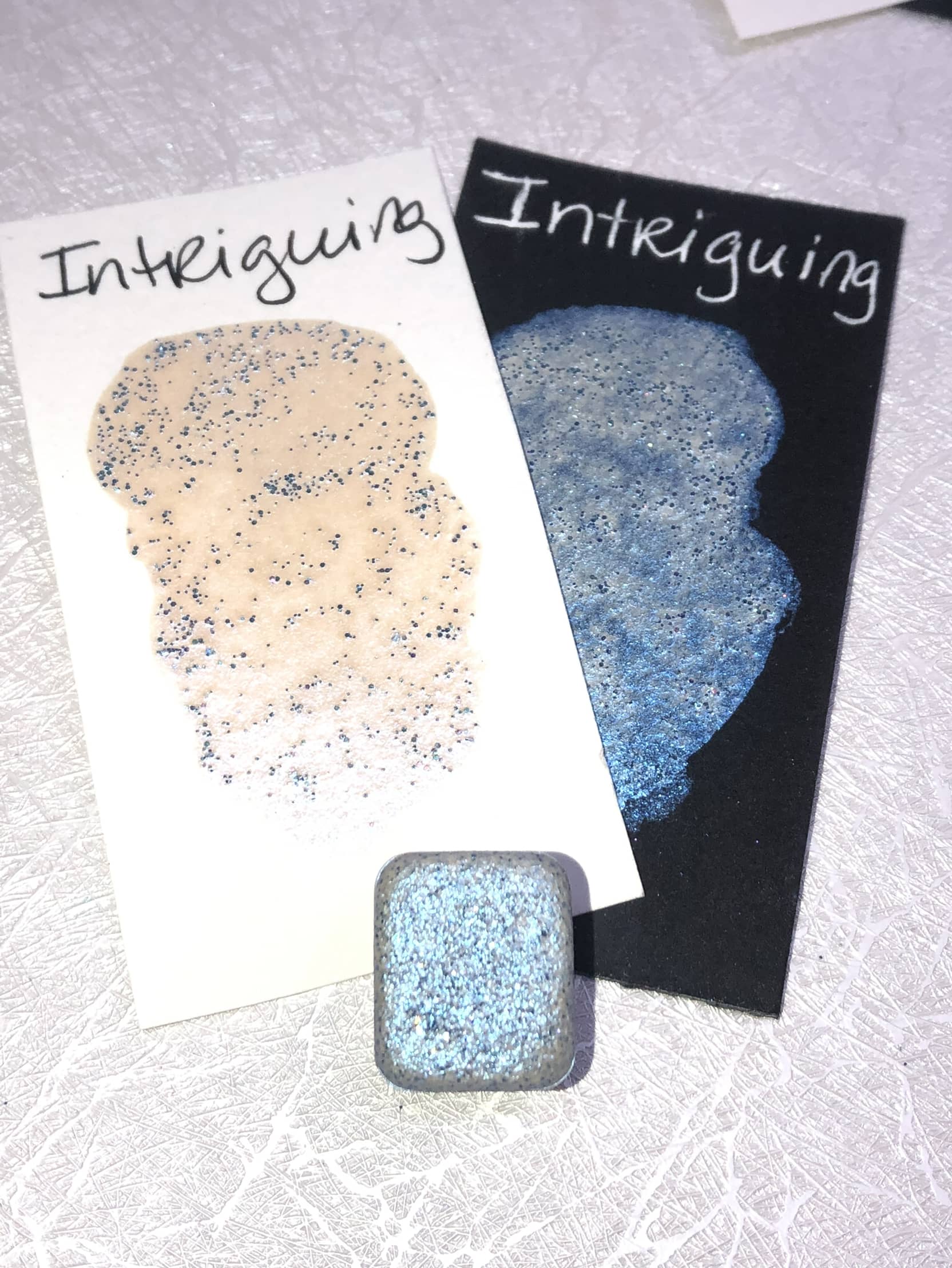 Intriguing shimmer watercolor paint half pan with swatch photo
